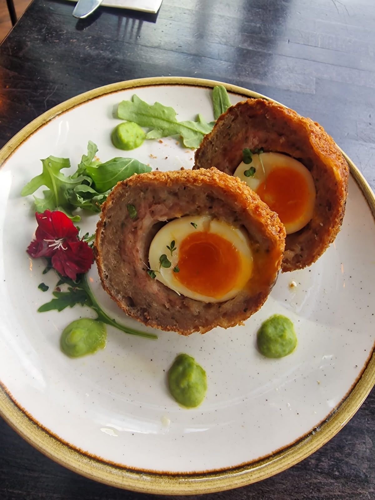 Scotch egg halves with pea purée and rocket