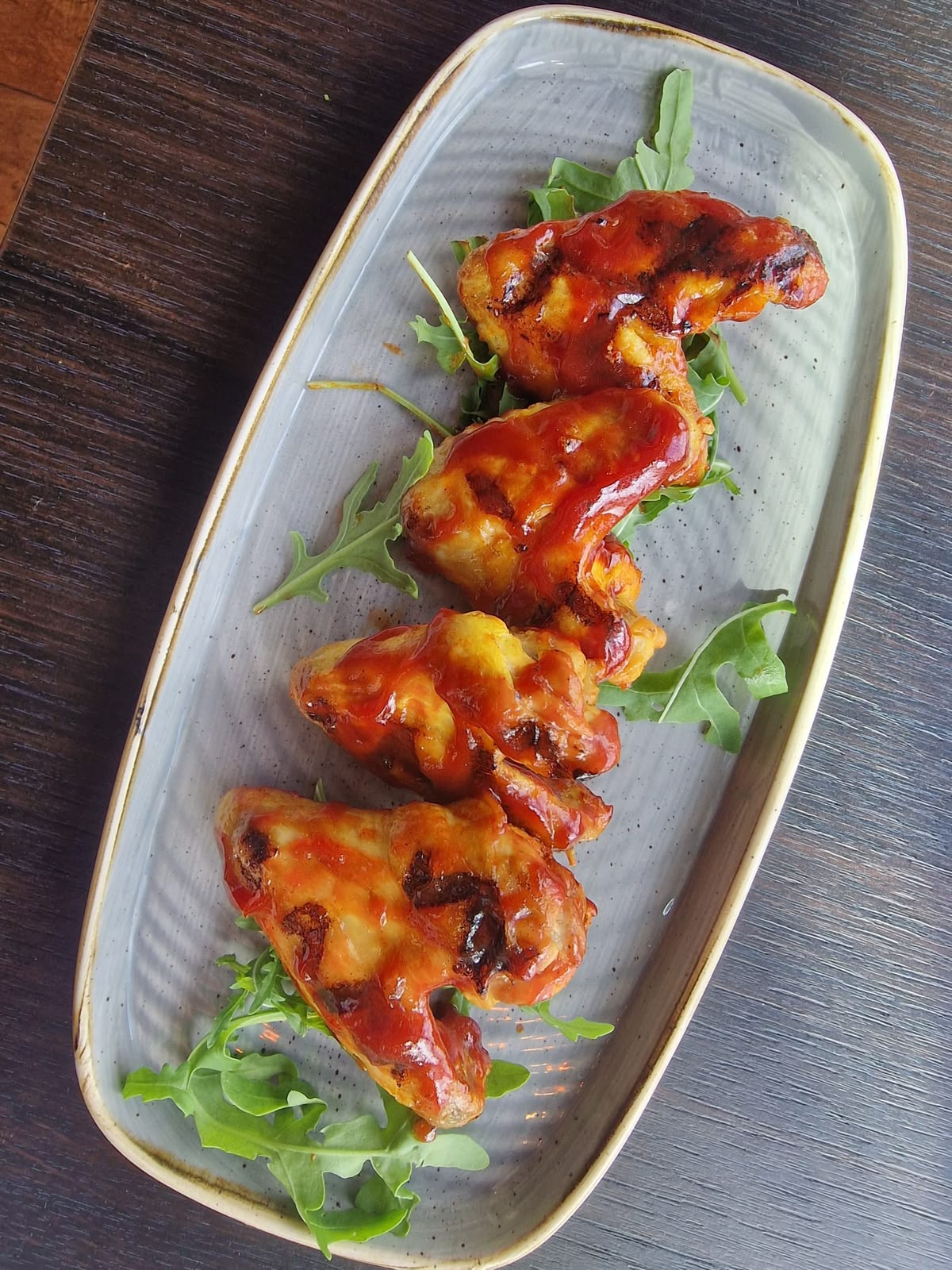 Sticky BBQ glazed crispy chicken on rocket