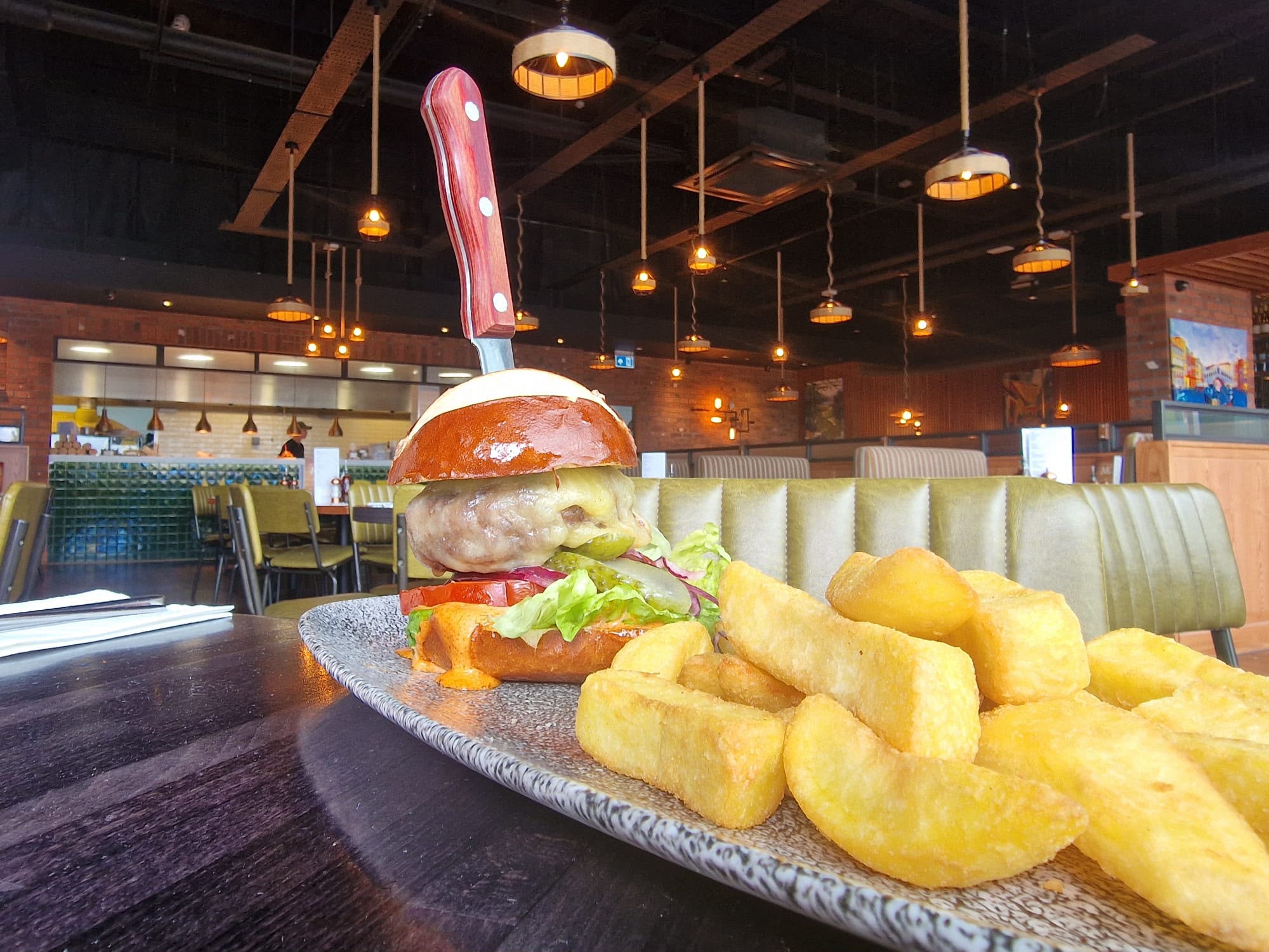 The dining room at grain, burger and chips in the foreground